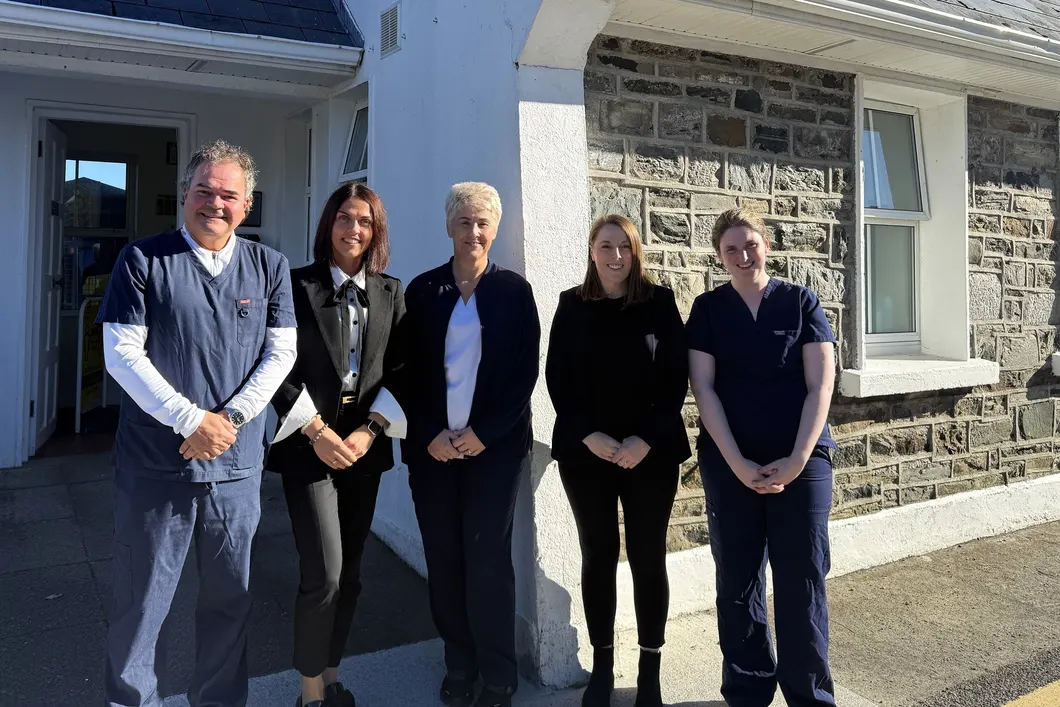 The five members of the Renvyle Health Centre team standing together at the practice entrance on a sunny day.